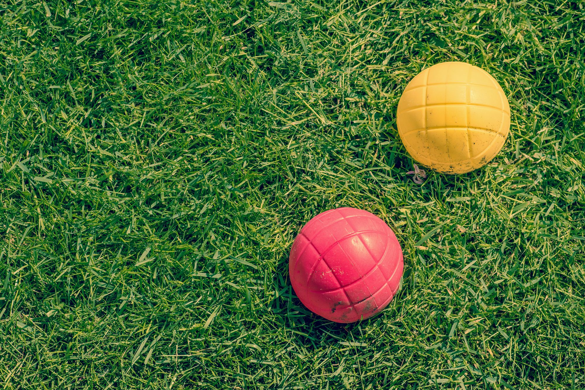 Red and Yellow Bocce Balls on Grass
