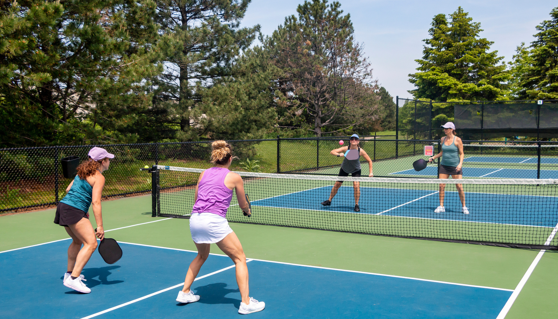 Pickleball doubles players in action on the court, demonstrating teamwork and dynamic play.